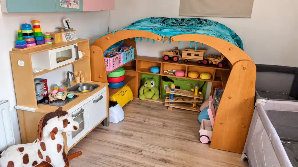 Spielecke mit Kinderküche und Spielbogen im Betreuungsraum